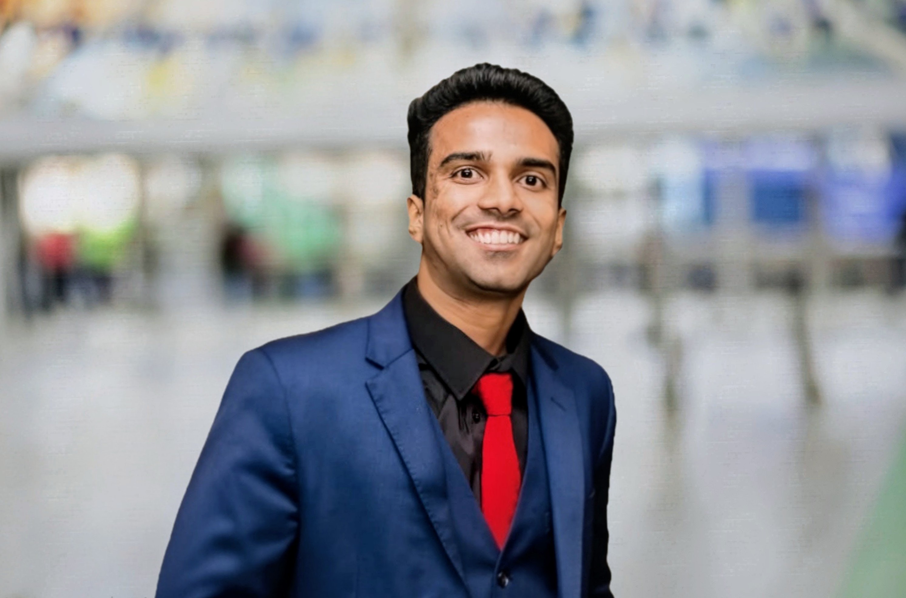 Hari Prasad Rangaraj smiling in a blue suit and red tie